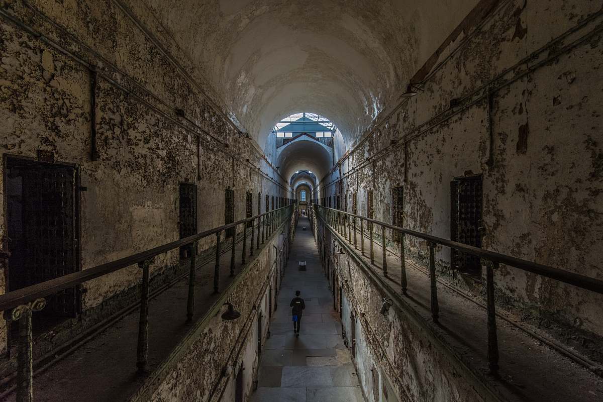 eastern state penitentiary man walking near cubicles inside building philadelphia